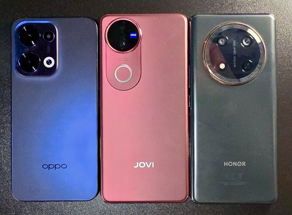 Oppo Reno 13 azul， Jovi V50 vermelho e Honor Magic7 Lite preto vistos por trás — Foto: Henrique Martin/g1